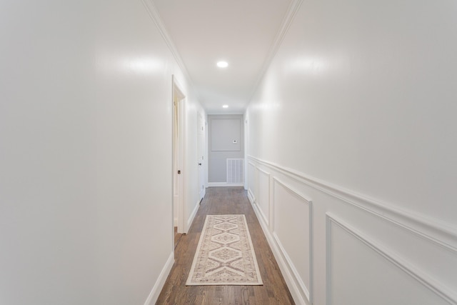 corridor with recessed lighting, visible vents, a decorative wall, ornamental molding, and light wood-type flooring