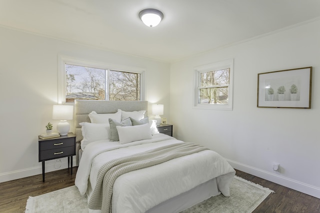 bedroom with ornamental molding, dark wood-type flooring, and baseboards