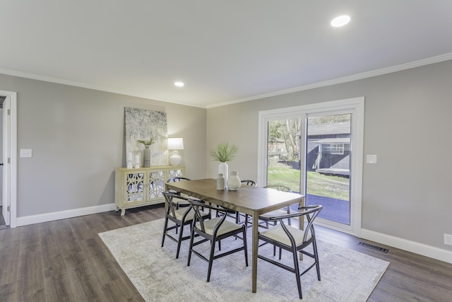 dining space featuring crown molding, dark wood finished floors, and baseboards