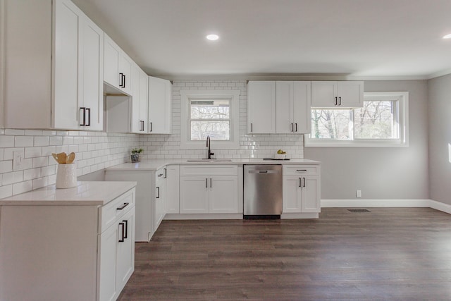 kitchen with visible vents, dark wood finished floors, backsplash, stainless steel dishwasher, and a sink