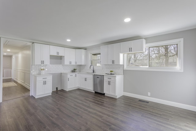 kitchen with dark wood-style floors, stainless steel dishwasher, visible vents, and decorative backsplash