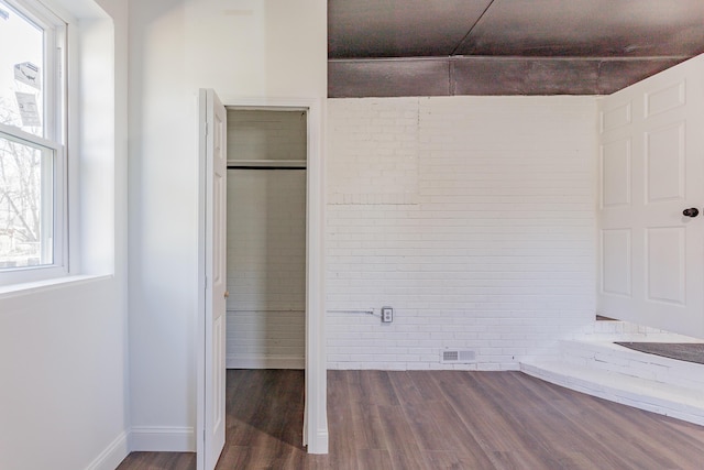 unfurnished bedroom featuring a closet, visible vents, baseboards, and wood finished floors