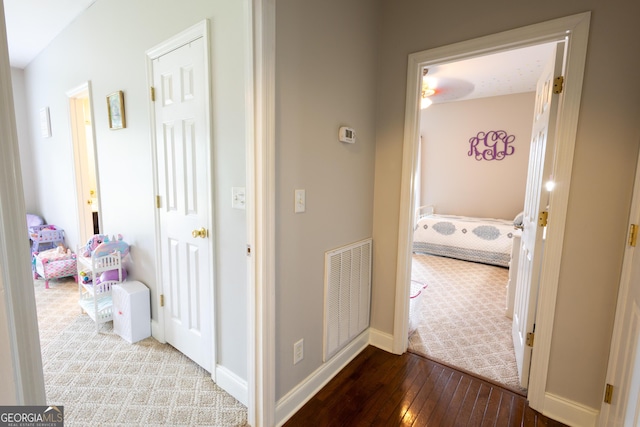 corridor featuring hardwood / wood-style flooring, baseboards, and visible vents