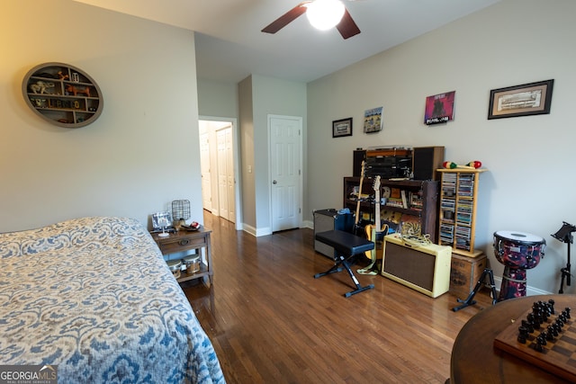 bedroom with dark wood-style floors, ceiling fan, and baseboards