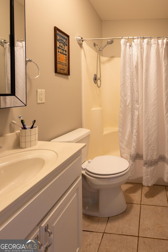 bathroom featuring toilet, vanity, a shower with shower curtain, and tile patterned floors