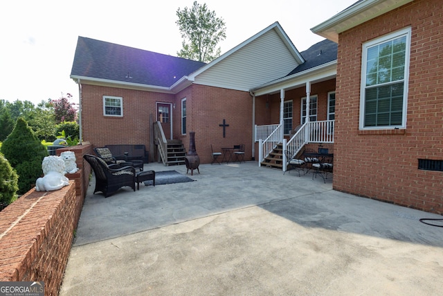 rear view of property with brick siding, a patio, and roof with shingles