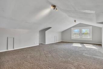 additional living space with carpet floors, vaulted ceiling, and baseboards