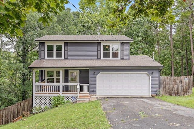 traditional home with a shingled roof, aphalt driveway, covered porch, fence, and a front yard