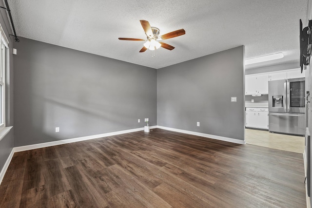 interior space featuring a textured ceiling, wood finished floors, a ceiling fan, and baseboards