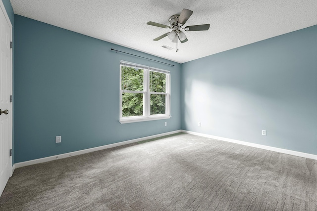 carpeted empty room with visible vents, a textured ceiling, baseboards, and a ceiling fan