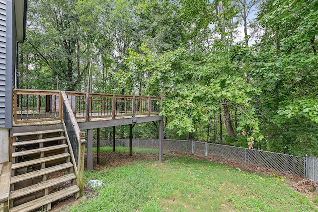 view of yard featuring a deck, stairway, and fence