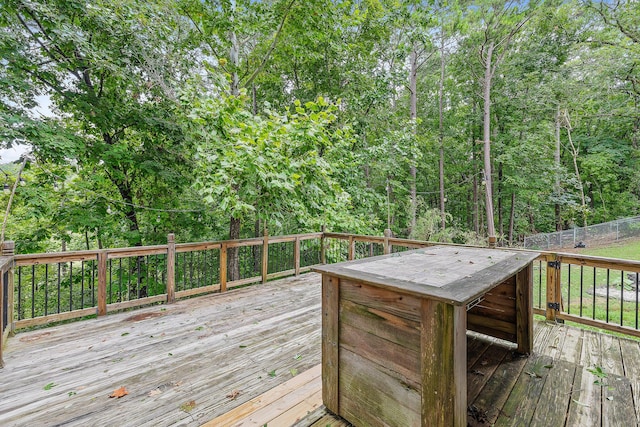 wooden terrace with fence and a view of trees