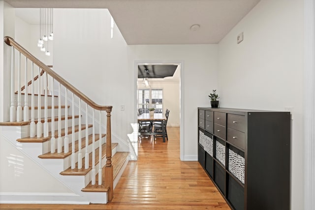 stairway with wood finished floors and baseboards