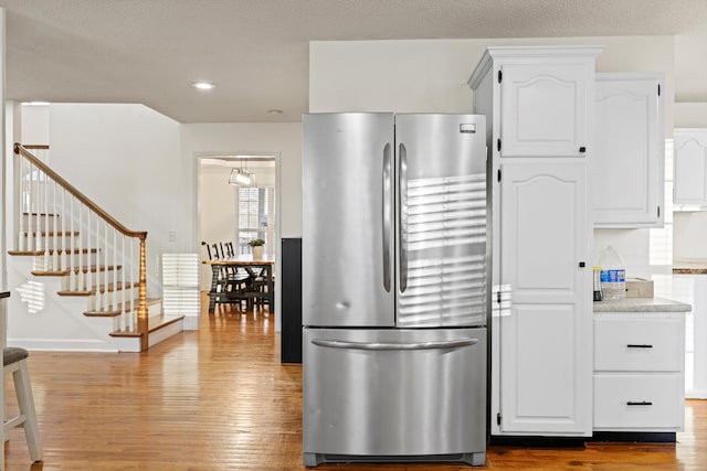 kitchen with recessed lighting, white cabinetry, wood finished floors, and freestanding refrigerator