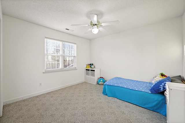 bedroom with carpet floors, visible vents, a ceiling fan, a textured ceiling, and baseboards