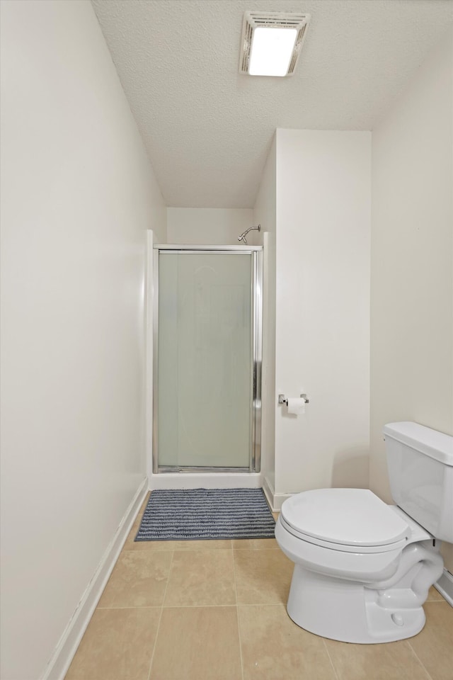 bathroom featuring toilet, a shower stall, visible vents, and tile patterned floors