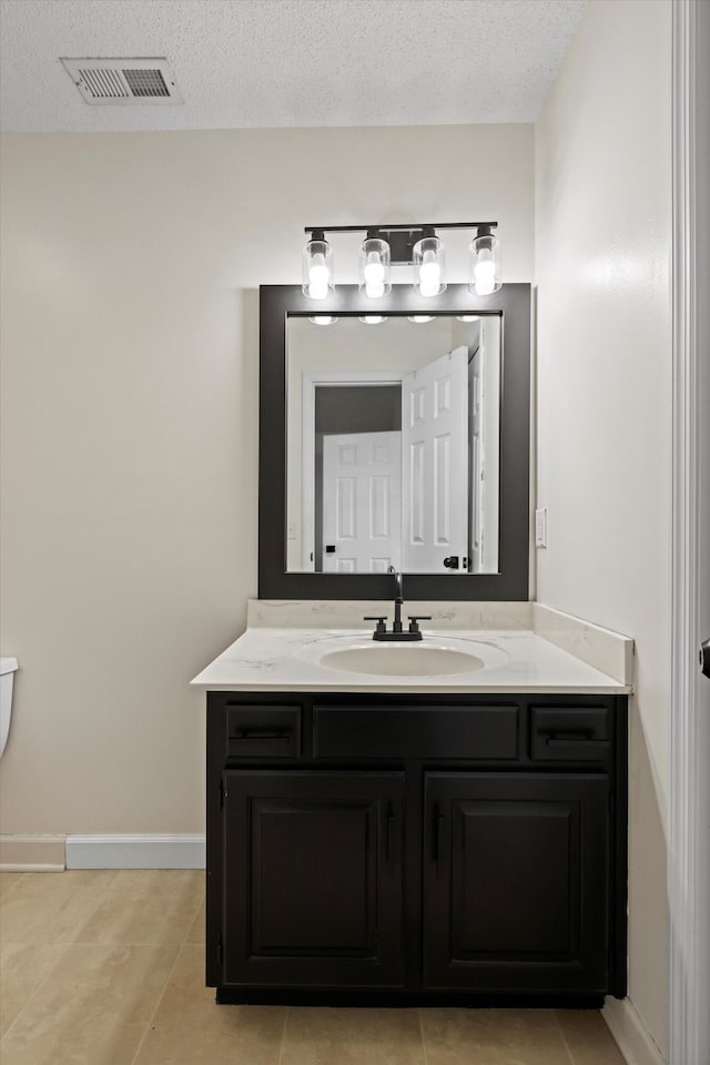 bathroom featuring baseboards, visible vents, vanity, and a textured ceiling