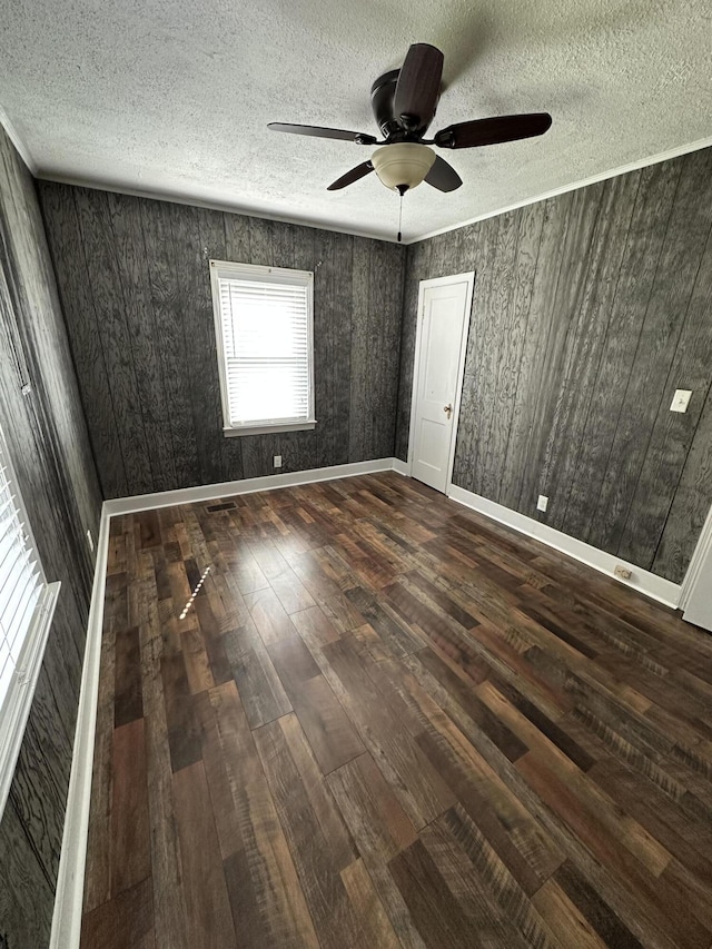 unfurnished bedroom featuring a textured ceiling, ceiling fan, dark wood-type flooring, and baseboards