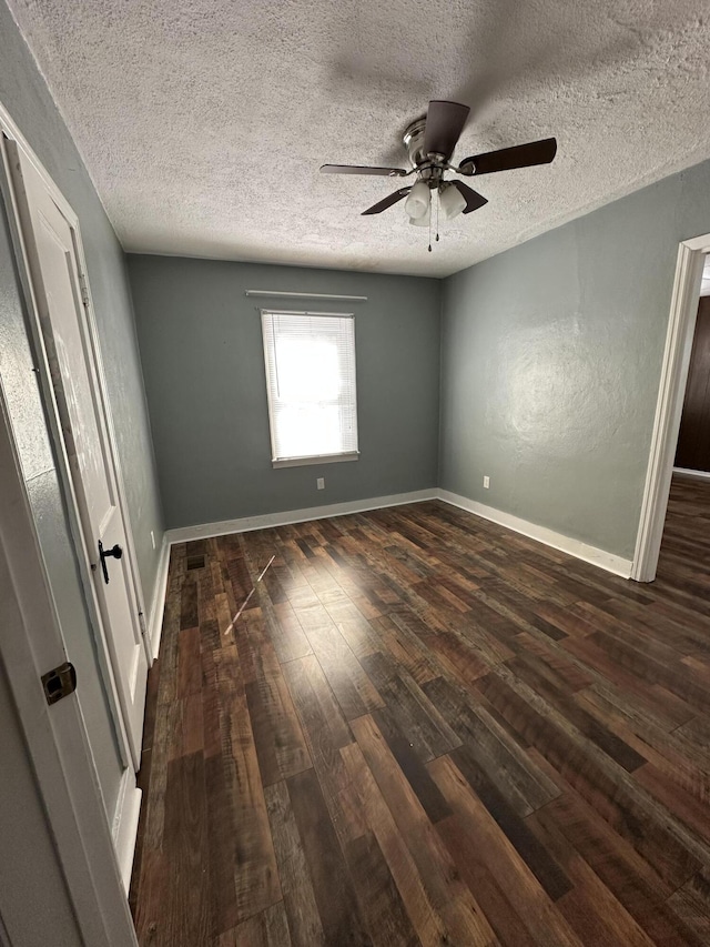 unfurnished bedroom featuring dark wood-style floors, ceiling fan, baseboards, and a textured ceiling