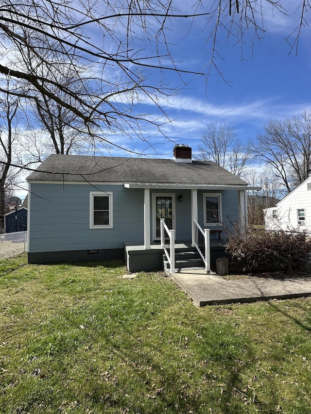 exterior space featuring crawl space, roof with shingles, a chimney, and a front lawn