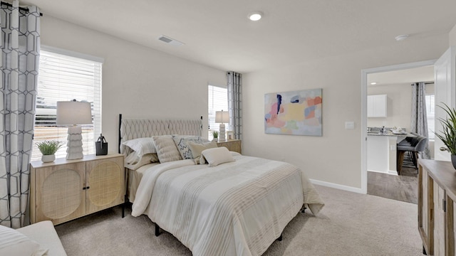 carpeted bedroom featuring recessed lighting, visible vents, and baseboards