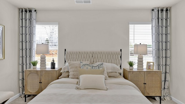 carpeted bedroom with visible vents and baseboards