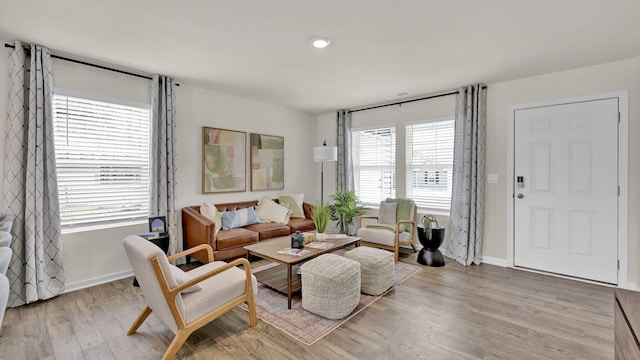 living area with light wood-type flooring and baseboards