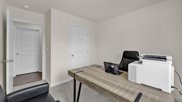 carpeted home office featuring baseboards