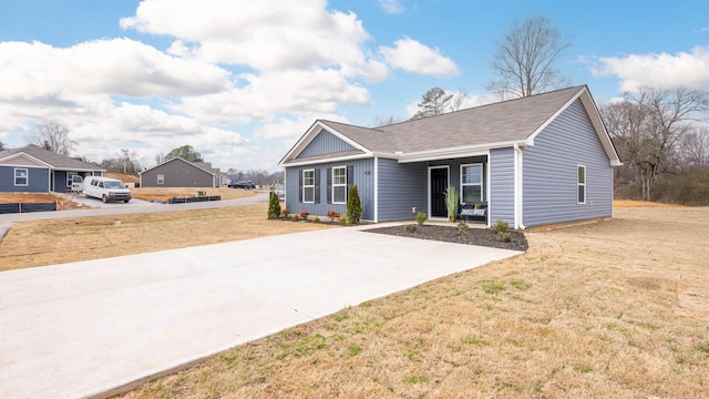 ranch-style home featuring board and batten siding, a front yard, and concrete driveway