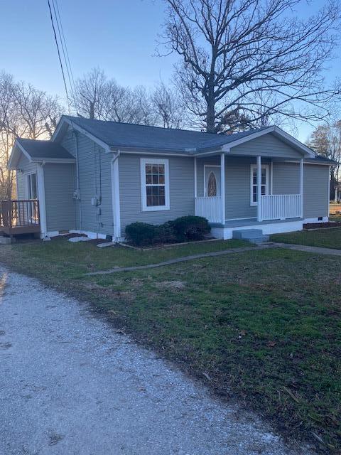 view of front of house featuring covered porch and a front yard