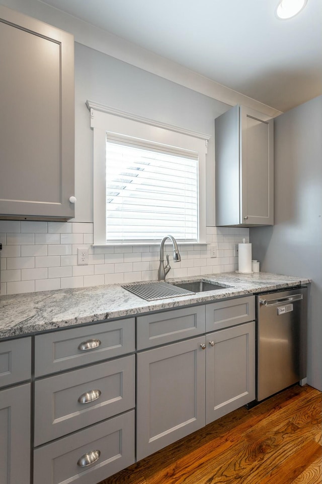 kitchen featuring dishwasher, a sink, and gray cabinetry