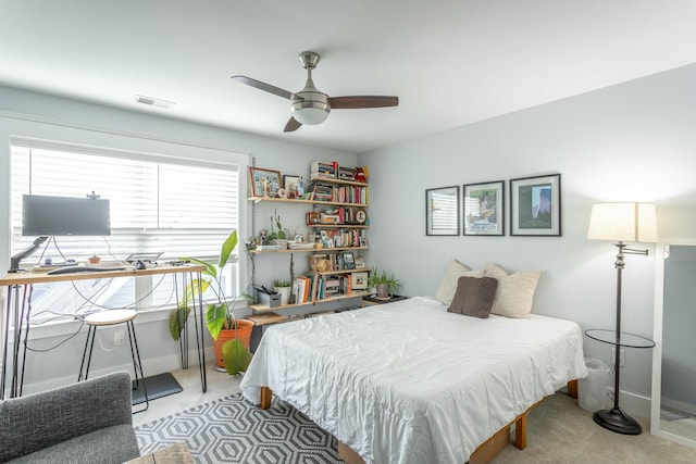 carpeted bedroom featuring a ceiling fan, visible vents, and baseboards