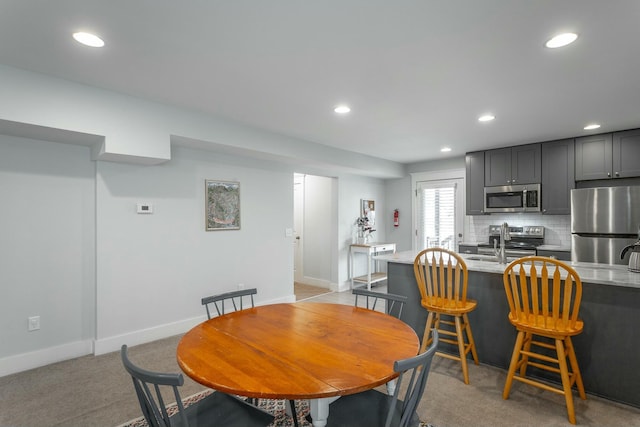 dining area featuring baseboards, light colored carpet, and recessed lighting