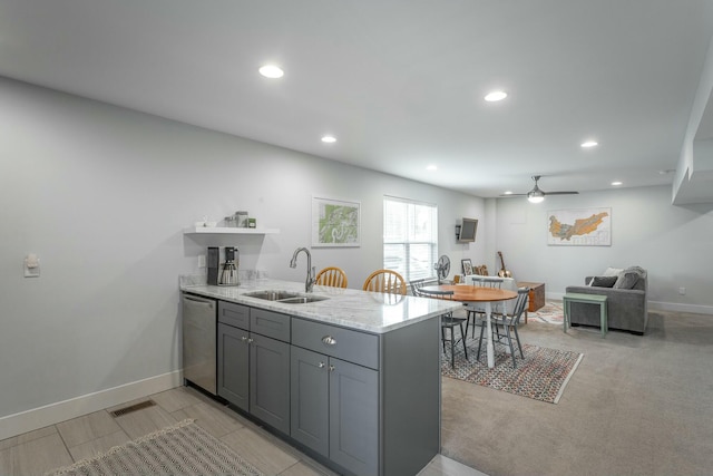 kitchen featuring a peninsula, a sink, gray cabinetry, open shelves, and stainless steel dishwasher