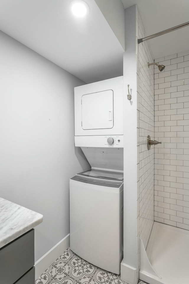 laundry area with laundry area, baseboards, and stacked washer and clothes dryer