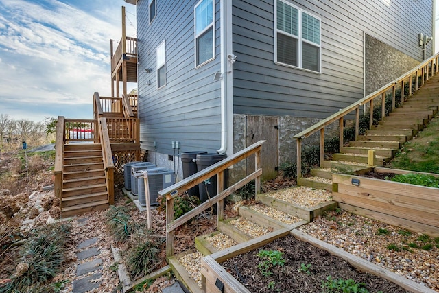 view of side of property featuring stairs and central AC