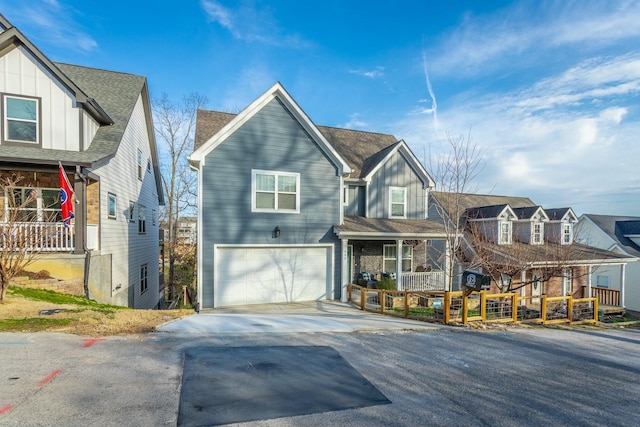 view of front of home featuring a garage, concrete driveway, a residential view, roof with shingles, and board and batten siding