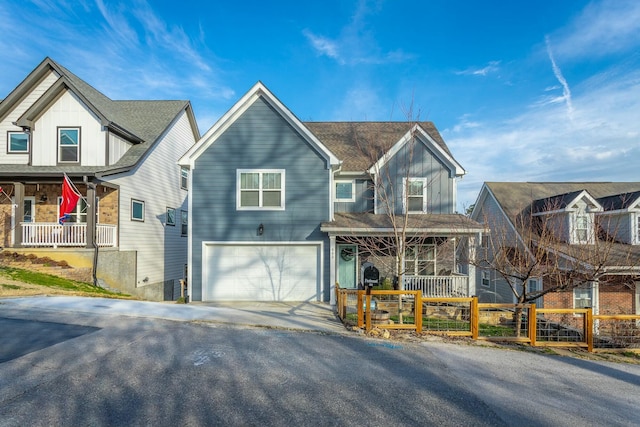 view of front of property with driveway, an attached garage, covered porch, fence, and board and batten siding