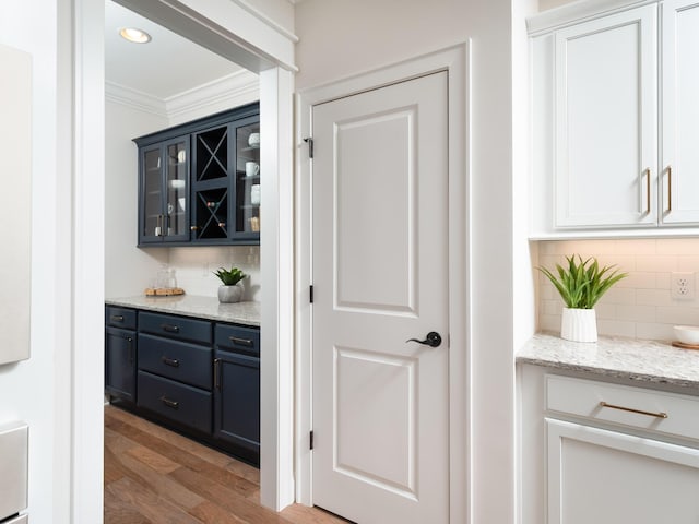 bar with light wood-style flooring, decorative backsplash, crown molding, and recessed lighting