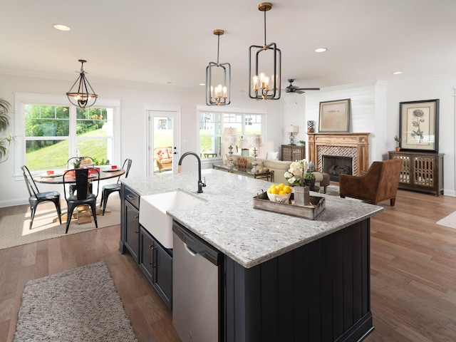 kitchen featuring a fireplace, dark wood-style floors, a sink, dishwasher, and crown molding