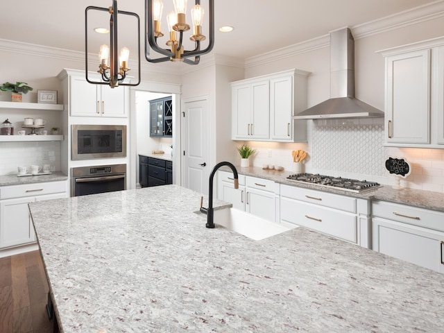 kitchen featuring open shelves, appliances with stainless steel finishes, ornamental molding, a sink, and wall chimney range hood