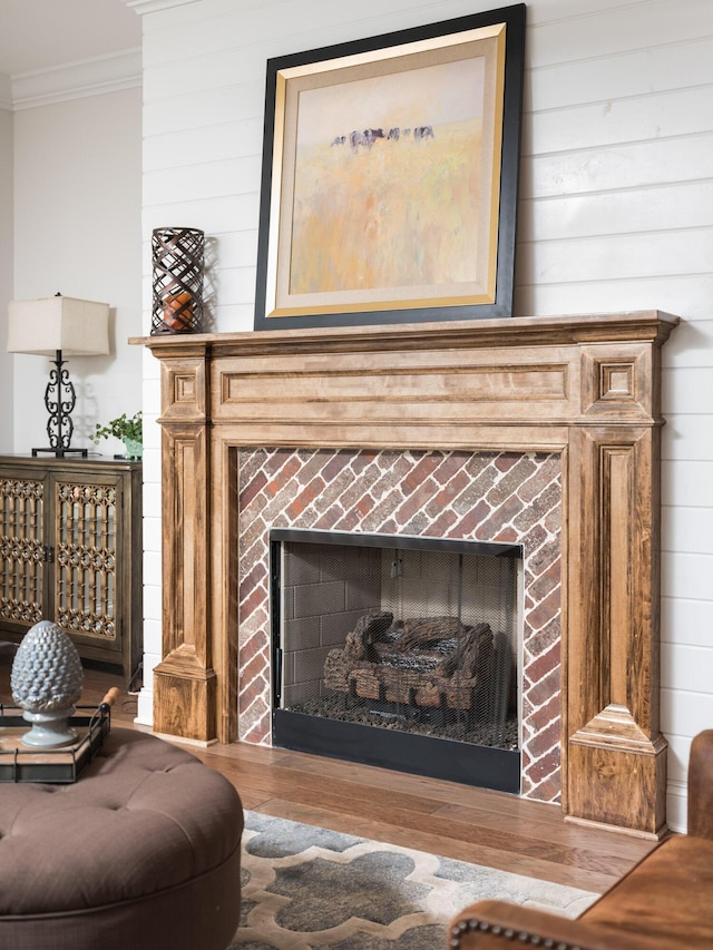 details featuring a fireplace, ornamental molding, and wood finished floors