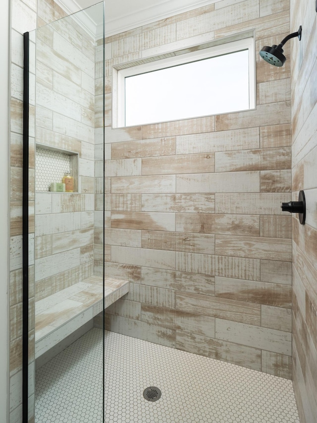 bathroom with tiled shower and crown molding