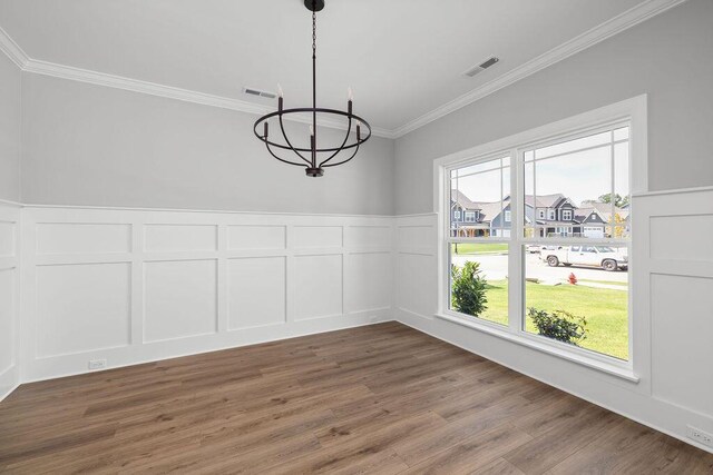 9676 Mayfly Rd # 10, Ooltewah, TN 37363 - unfurnished dining area with a chandelier, a decorative wall, crown molding, wood finished floors, and wainscoting