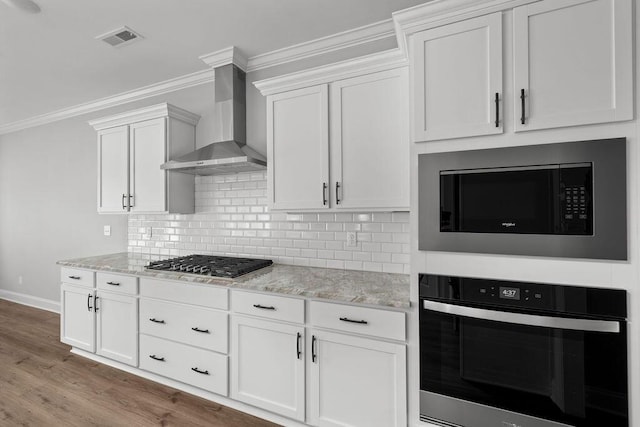 9676 Mayfly Rd # 10, Ooltewah, TN 37363 - kitchen with appliances with stainless steel finishes, wall chimney range hood, ornamental molding, light stone counters, and tasteful backsplash
