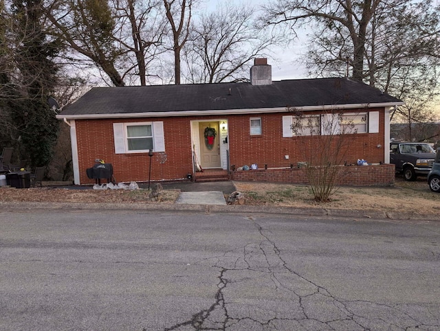 view of front of property with brick siding and a chimney