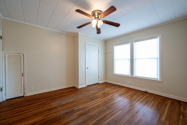 empty room featuring a ceiling fan, baseboards, ornamental molding, and wood finished floors