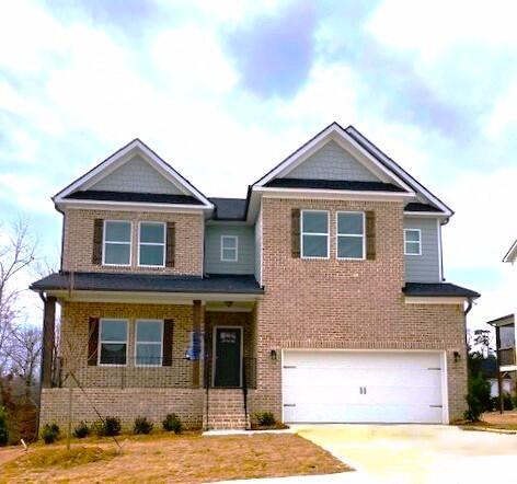 craftsman-style house with an attached garage, concrete driveway, and brick siding