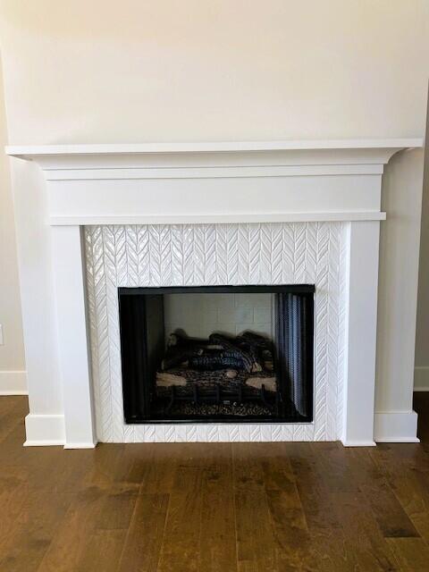 interior details with a fireplace, wood finished floors, and baseboards