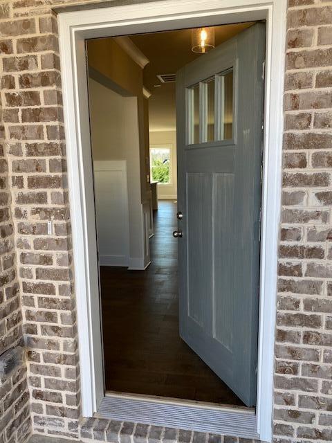 doorway to property featuring brick siding